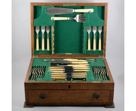 An oak canteen of Walker &amp; Hall silver-plated cutlery, six place settings in the rat-tail design with servers, knife rest