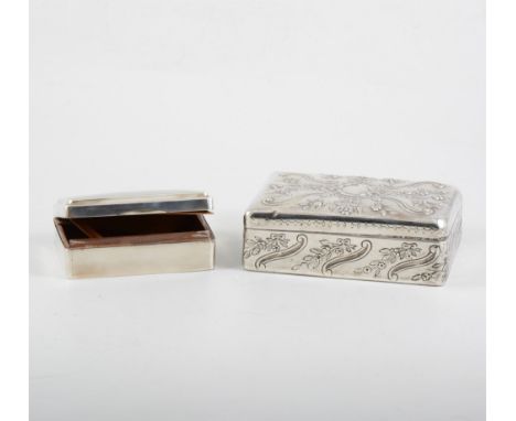 Two silver cigarette/jewel boxes, cedar lined, one with embossed floral and scroll decoration around a vacant cartouche, 17cm