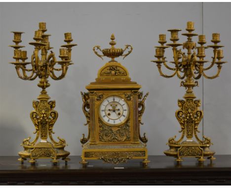 French cast brass three-piece clock garniture, modern, the clock case with urn finial, scrolled ring mark handles, circular d