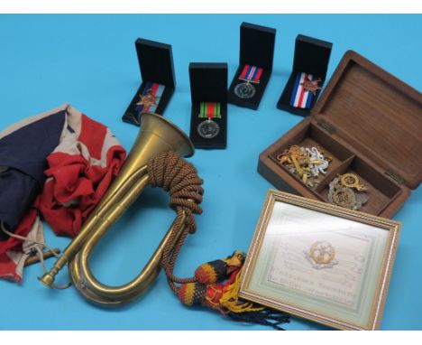 Militaria, including cap badges, brass bugle, four medals, etc.