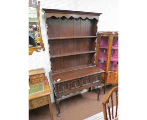 A small 18th century-style oak dresser, twin-shelf plate rack with shaped pediment, two-drawer base, on front cabriole legs, 