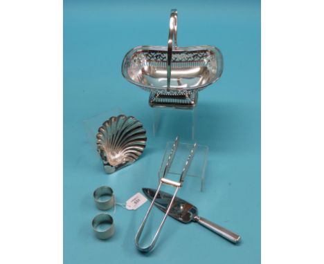 A silver shell dish, pair of engine-turned silver napin rings, a pierced silver plated bread basket with swing handle and two