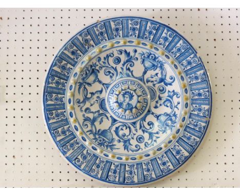 A 19th century Italian majolica wall plate, painted with central portrait boss and leafage in Renaissance-style, 16in. 