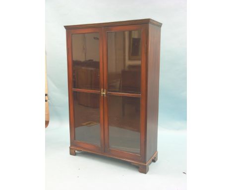 A Victorian mahogany bookcase, three shelves enclosed by a pair of mahogany-stained pine glazed doors, bracket feet, 3ft. 2in
