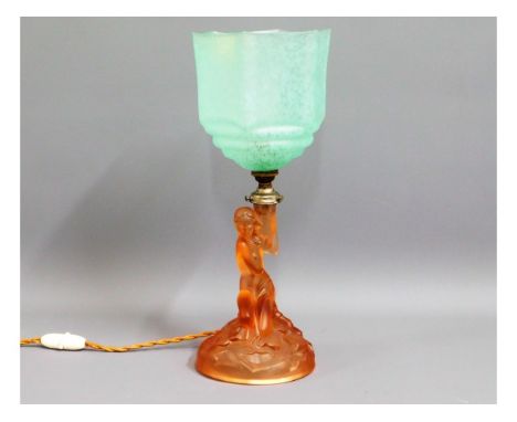 A 1930's art deco glass lamp featuring amber nymph holding mottled green shade, 15.5in tall