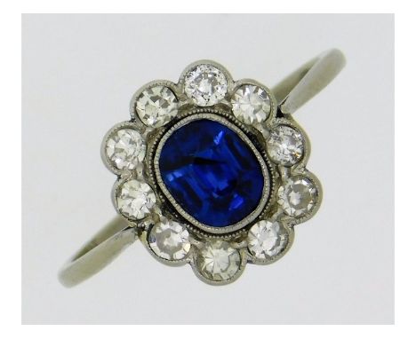 An early 20thC. platinum ring set with cushion cut sapphire of approx. 0/.65ct &amp; ten lively diamonds of approx. 0.5ct &am