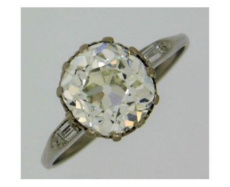 An antique, white metal, electronically tests as 18ct gold, diamond ring with baguette cut shoulders, lively centre stone app