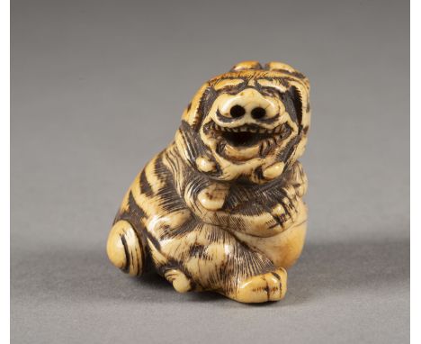 EIN GESCHNITZTES NETSUKE EINES SHISHI AUS ELFENBEIN Japan, 18./19. Jahrhundert Elfenbein. H. 3.7 cm. Das Netsuke ist als sitz