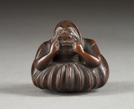 EIN HOLZGESCHNITZTES ASCHENBECHER-NETSUKE VON DARUMA Japan, 19. Jahrhundert Holz. H. 3.9 cm. Das Netsuke ist als Daruma gesch