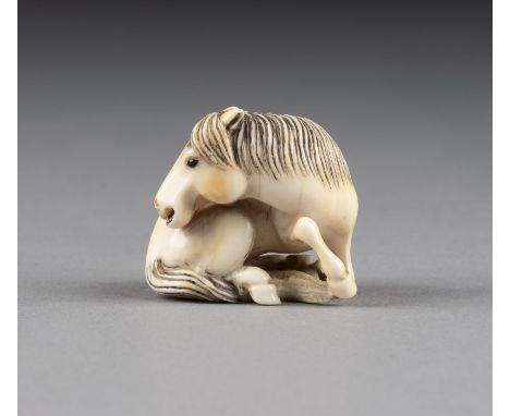 EIN GESCHNITZTES NETSUKE EINES PFERDES AUS ELFENBEIN Japan, 19. Jahrhundert Elfenbein. H. 2.8 cm. Das Netsuke ist als ein lie