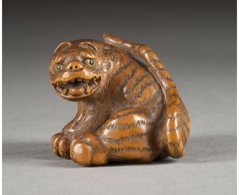 EIN HOLZGESCHNITZTES NETSUKE EINES TIGERS Japan, spätes 19. Jahrhundert Wood. H. 3.3 cm. Das Netsuke ist als ein sitzender Ti