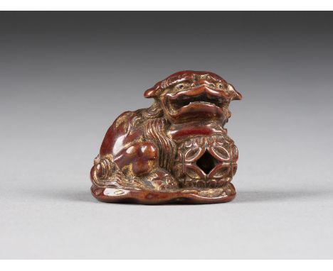 EIN LACKIERTES UND VERGOLDETES HOLZGESCHNITZTES NETSUKE VON SHISHI Japan, 19. Jahrhundert Holz. H. 3.2 cm. Das Netsuke ist al
