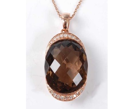 A rose metal, smoky quartz and diamond pendant, the smoky quartz fashioned as an oval briolette cut set within two curved ban