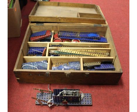 A stained wooden box containig a collection of loose Meccano, together with a part built model