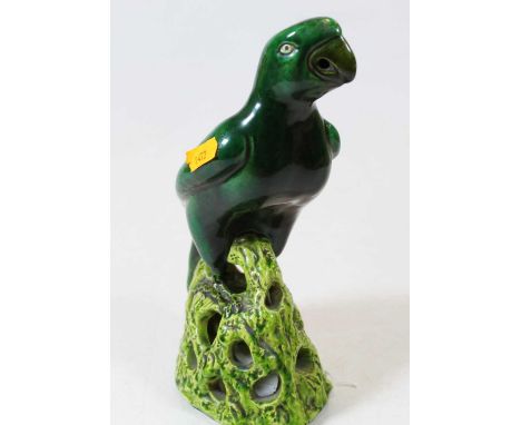An early 20th century green glazed pottery model of a parrot raised on a pierced naturalistic base, height 23cm