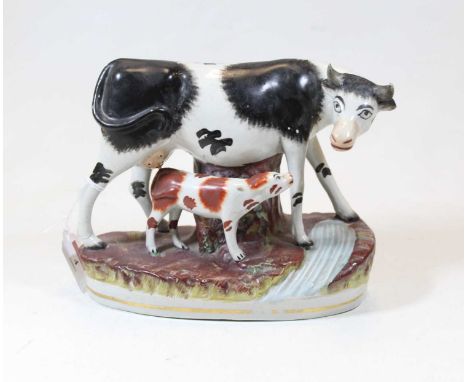 A 19th century Staffordshire model of a cow and calf beside a river, h.18cm