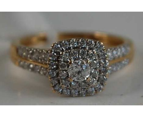 A modern 18ct gold diamond cluster ring, arranged as a centre four-claw set brilliant weighing approx 0.15 carats, within two