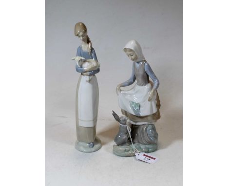 A Lladro Spanish porcelain model of a young girl with a rabbit at her feet having a printed mark verso, height 24cm, together