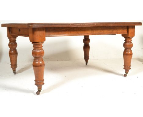 A 19th Century Victorian oak extendable dining table, flared canted frieze raised on turned baluster supports terminating on 