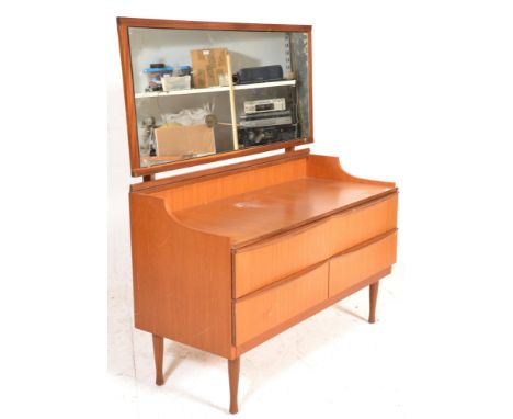 A vintage retro 20th Century teak wood dressing table chest having a large central mirror panel with teak frame above a confi