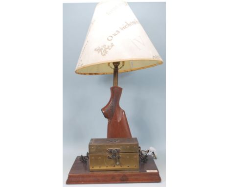 An unusual 20th century table lamp formed from the stock of a rifle / shotgun complete with shade being set to a wooden plint