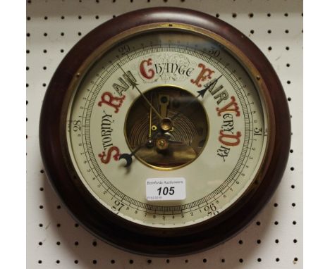 A circular wall mounted aneroid barometer, mahogany mount.