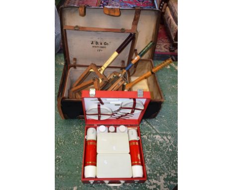 An early 20th century canvas and leather bound trunk; another travel case; a Sirram picnic set; wooden tennis rackets and bra