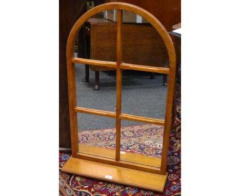 A contemporary arched mirror above a shelf