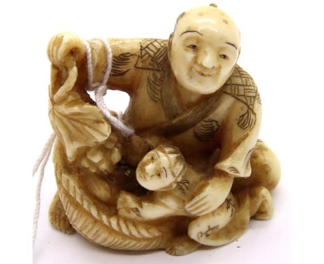 Ivory carved netsuke in the form of a seated man with a child holding a fruit group, H: 34 mm, signed panel to base. P&amp;P 