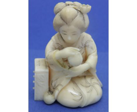 Carved ivory figurine of a kneeling lady holding a ball, H: 42 mm. P&amp;P Group 1 (£14+VAT for the first lot and £1+VAT for 