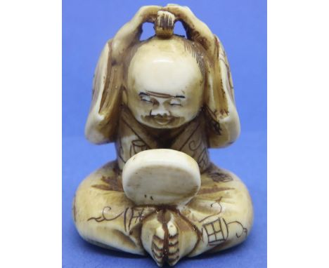 Ivory carved netsuke in the form of a man styling his hair in front of a mirror, H: 40 mm, signed to base. P&amp;P Group 1 (£