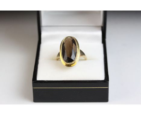 Smoky quartz 9ct yellow gold dress ring, oval mixed cut smokey quartz, rub over setting with flat border surround, size of he