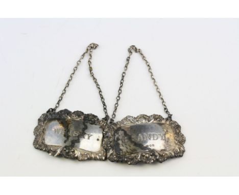 Pair of silver decanter labels: Brandy and Whisky, repousse foliate border decoration, makers Richards &amp; Knight, London 1