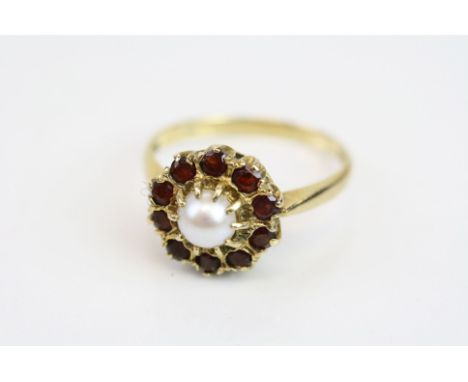 Pearl and garnet 9ct yellow gold cluster ring, central white pearl with pink overtones, ten small round faceted garnet surrou