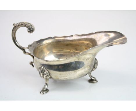 Edwardian silver sauce boat, raised on three hoof feet, scroll handle with cast acanthus leaf, ogee border, makers Haseler Br