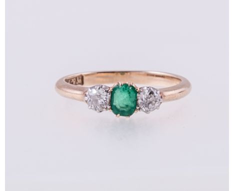 An emerald and diamond three stone ring, a step cut emerald 5mm x 4mm, four claw set with a brilliant cut diamond to each sid