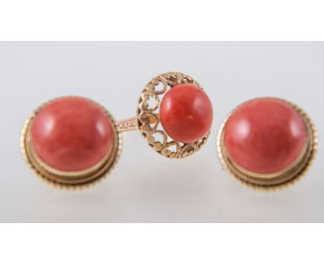 A coral dress ring and pair of coral earrings, a 12.5mm cabochon coral peg set on a yellow metal ring mount with pierced hear