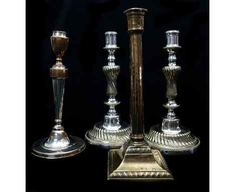 A pair of silver plate on brass candlesticks, the circular bases cast with wrythen fluting within beaded borders; a single Ol