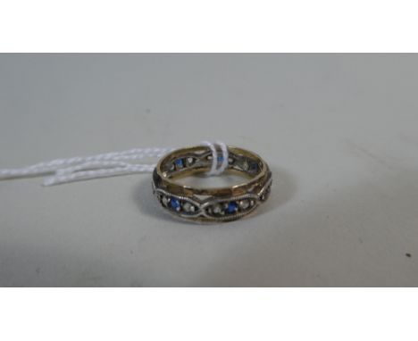 A Yellow and White Metal Edwardian Eternity Ring with Blue and White Stones