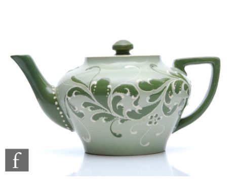 Harry Barnard - James Macintyre &amp; Co - A late 19th Century Gesso Faience teapot decorated with tonal green foliage agains