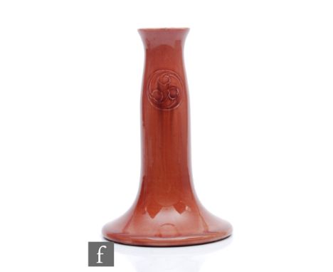 William Moorcroft - An early 20th Century Flamminian Ware candlestick glazed in red with tubelined roundels,&nbsp;Moorcroft M