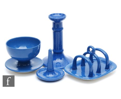 William Moorcroft - Four pieces of Powder Blue comprising a candlestick, a toast rack, a ring holder and a sundae dish, all w