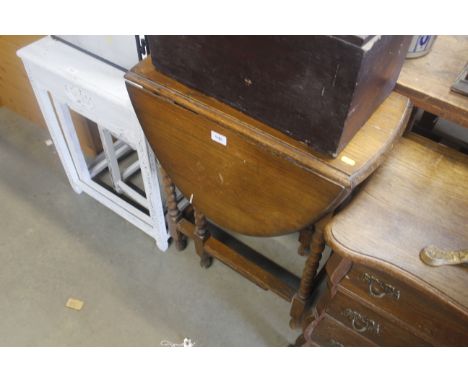 An oak gate leg table raised on bobbin turned supports