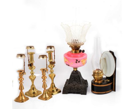 Two pairs of brass candlesticks, serving as peg lamps; a wall hanging Toleware oil lamp, with reflector shade, 28cm; and anot