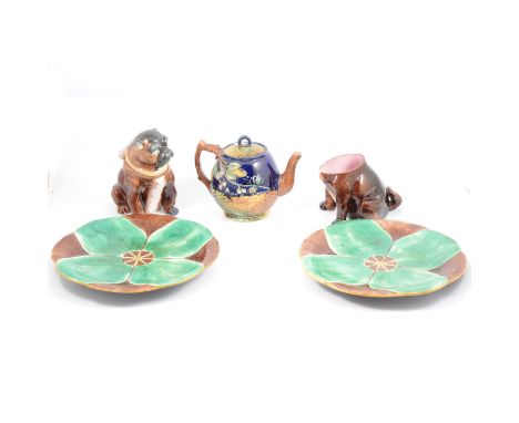 A Majolica novelty jar and cover, modelled as a seated Pug dog, 20cm high; another with lacking cover; a majolica teapot, the