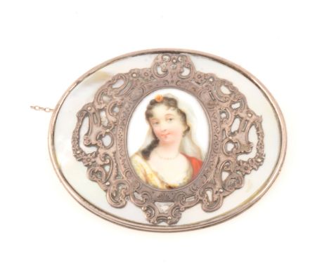 Large oval brooch with portrait miniature to centre, mother-of-pearl plaque with applied silver coloured scroll work around a