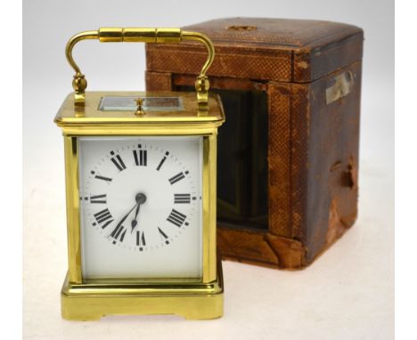 A brass carriage clock with repeating English movement striking on a coiled gong, with bevelled glass panels, enamel dial and