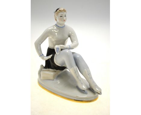 An Art Deco style Lomonosov porcelain model of a seated skater, rubbed marks to base, 17 cm h.