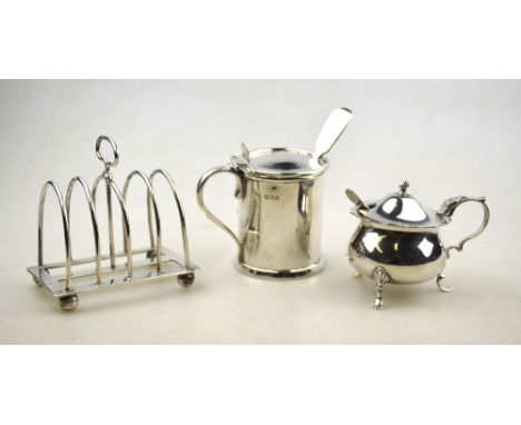 A Victorian silver small toast-rack, William Hutton & Sons, London 1881, to/w two mustards with blue glass liners (3)