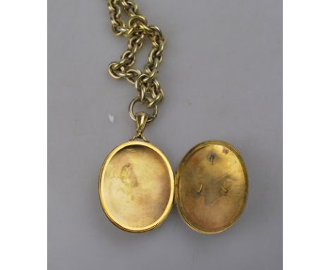 A large Victorian gilt metal hinged locket with applied monogram on Victorian cable style chain